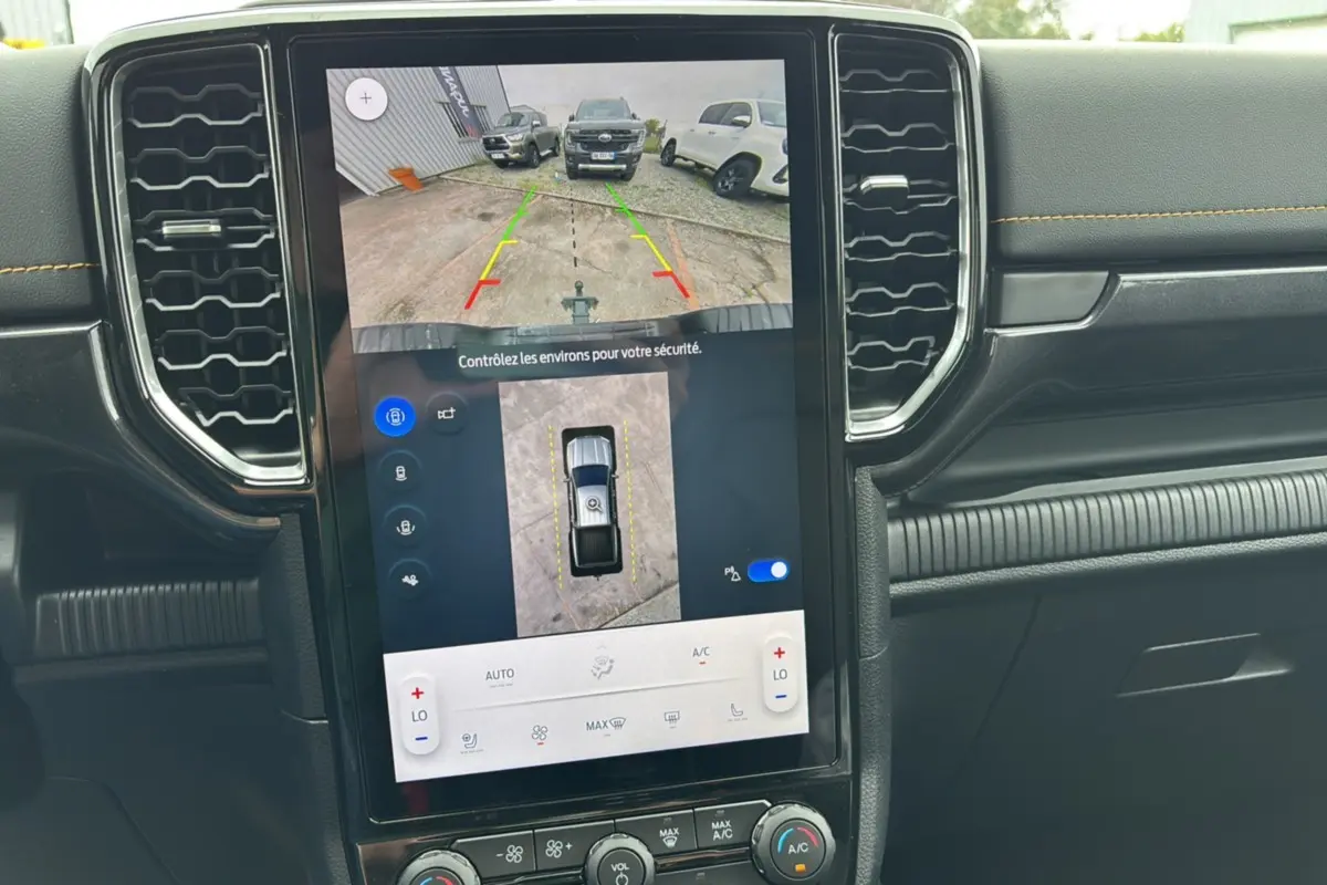 Vue rapprochée de l’écran central tactile du Ford Ranger Wildtrak 2025 noir agate montrant la caméra 360° et l’aide au stationnement.