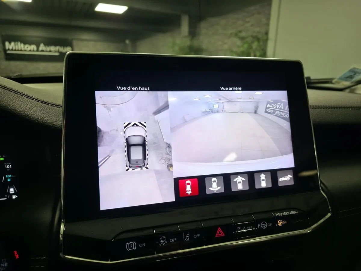 Écran central affichant la caméra 360° et vue arrière du Jeep Compass noir en stationnement intérieur.