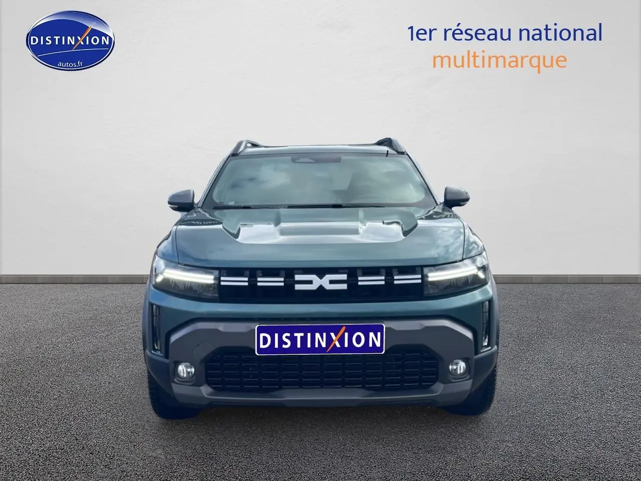Vue frontale d'un Dacia Duster 1.2 mild hybrid 140 Journey vert cèdre avec phares LED allumés et calandre noire.