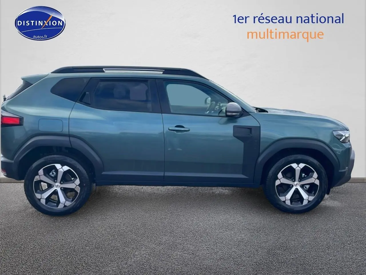 Profil droit du Dacia Duster 2026 vert cèdre avec barres de toit et jantes alliage visibles.