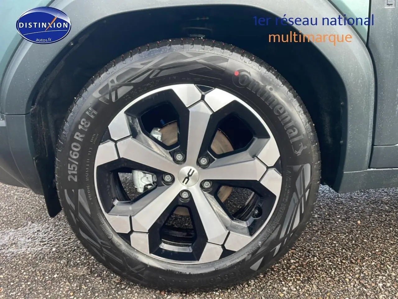Gros plan sur la roue avant droite du Dacia Duster vert cèdre, mettant en valeur la jante alu au design moderne.
