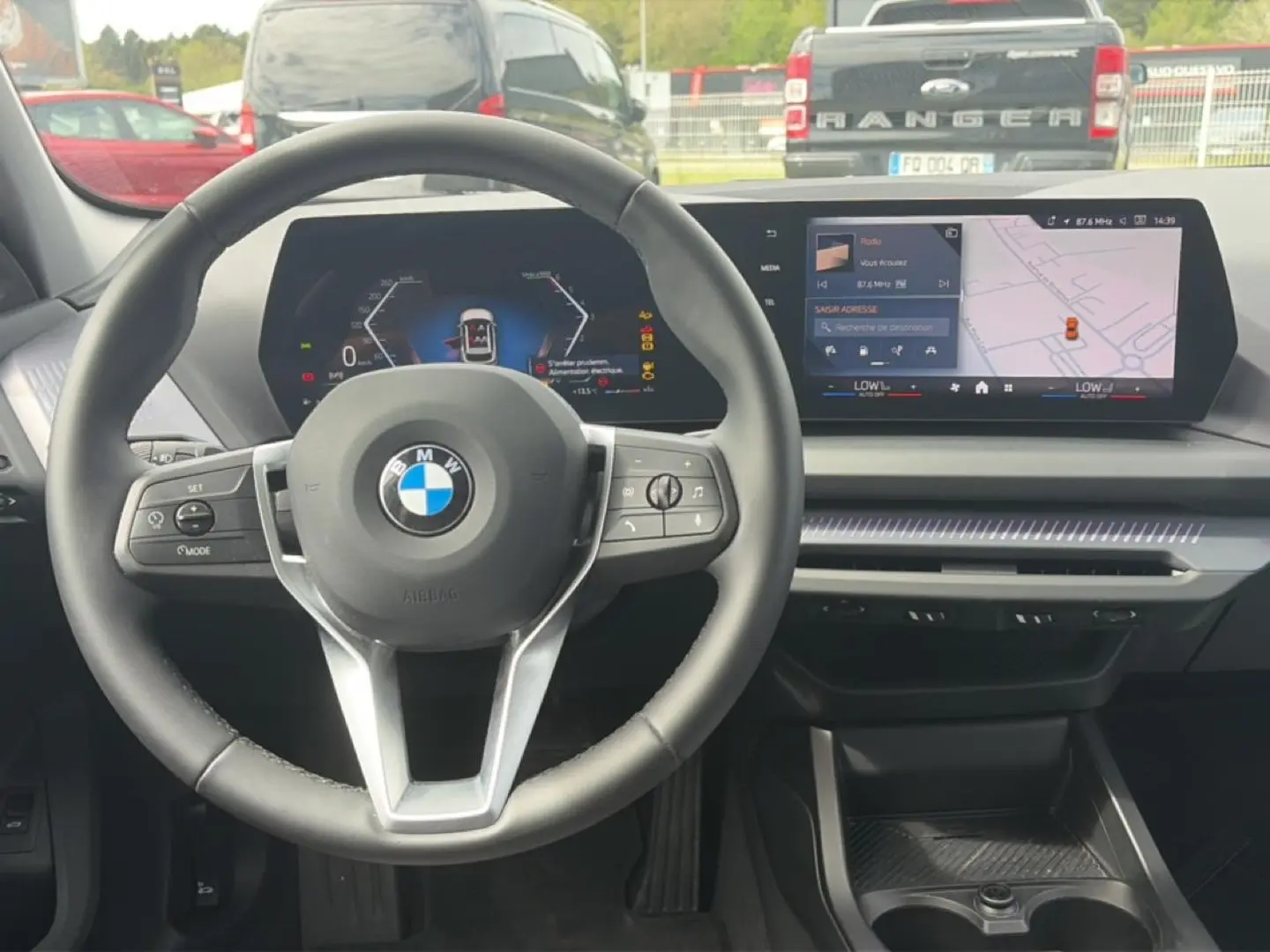 Vue intérieure frontale du volant cuir noir et tableau de bord numérique de la BMW Série 1 120da M Sport 2025.