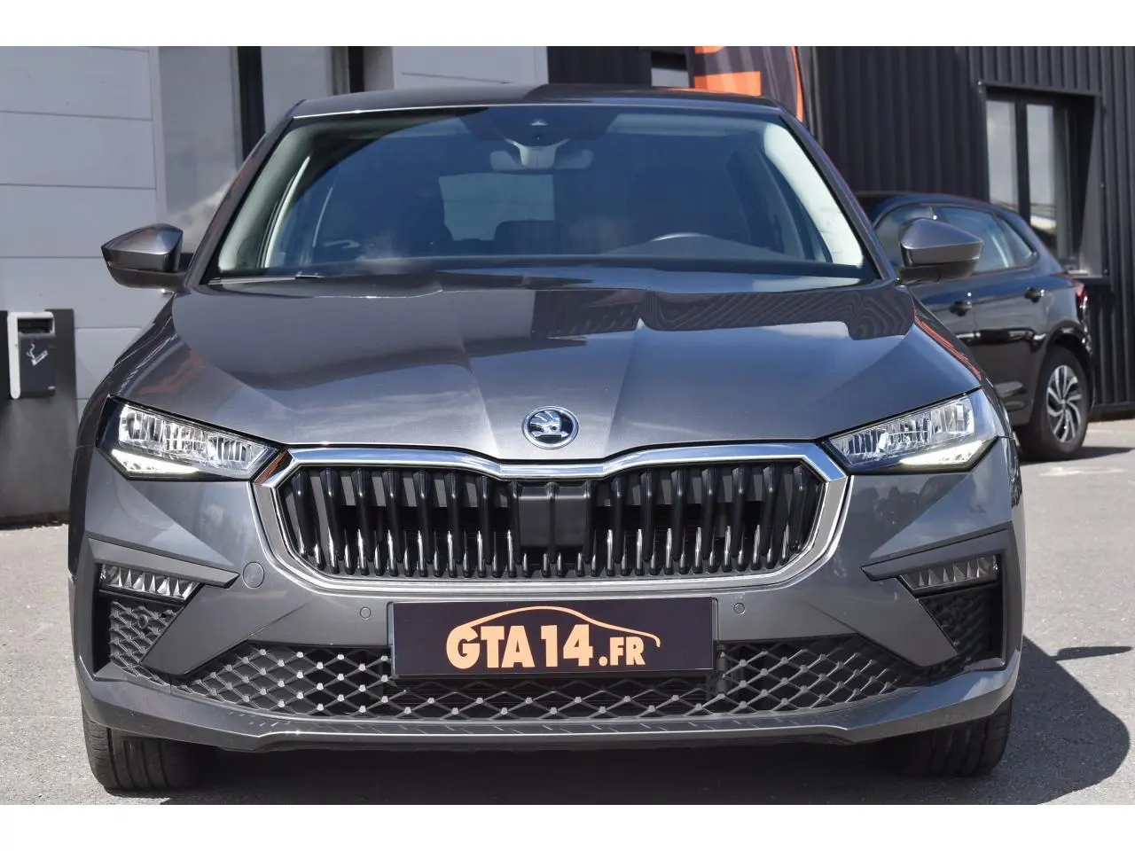 Vue avant frontale d'une Skoda Scala gris graphite avec calandre noire et phares LED distinctifs.