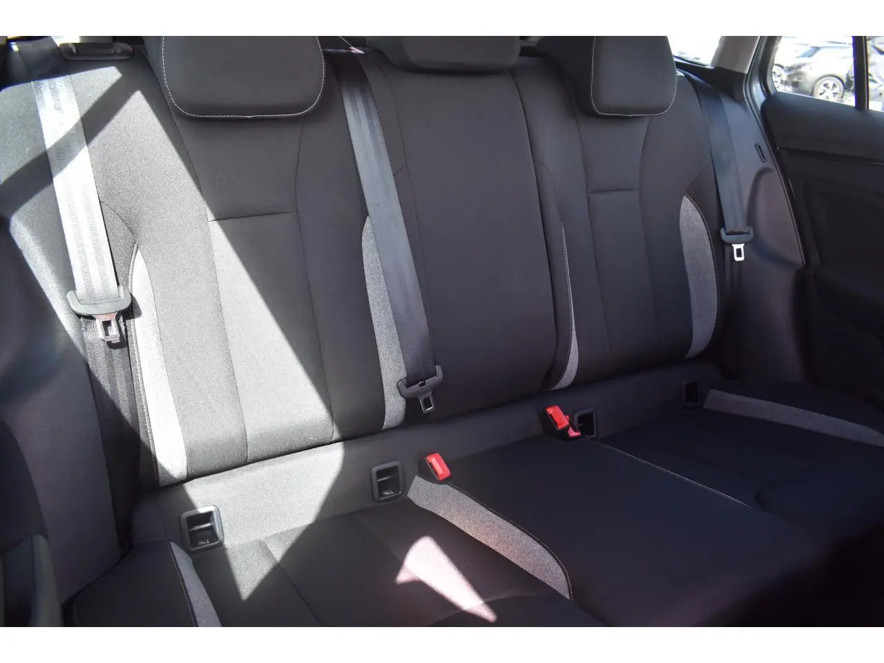 Vue intérieure des sièges arrière en tissu noir et gris de la Skoda Scala 2025, avec ceintures de sécurité visibles.