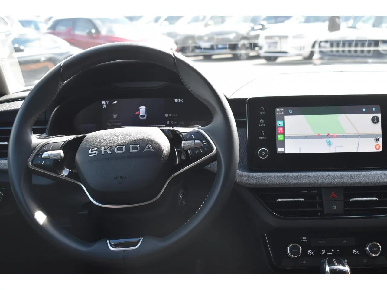 Vue intérieure centrée sur le volant cuir SKODA et l'écran tactile de navigation du tableau de bord.