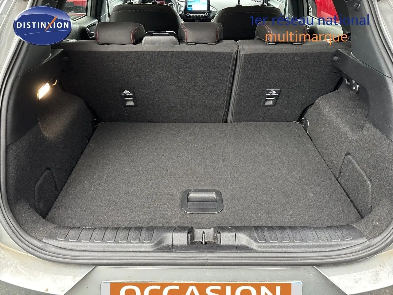 Coffre ouvert du Ford Puma gris Solar, vue arrière montrant l'espace de chargement et les sièges rabattus.