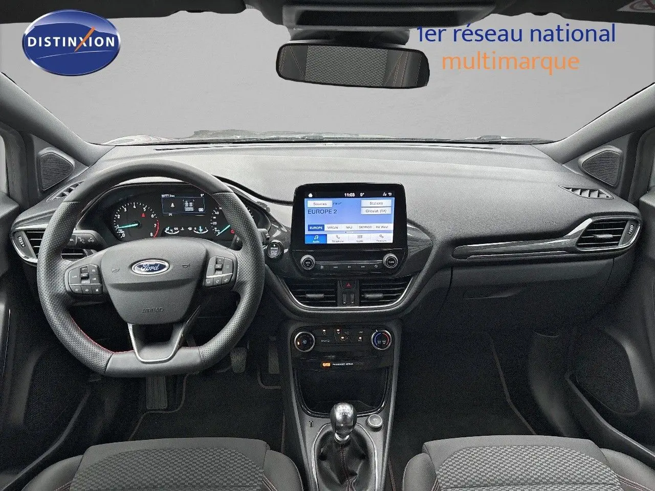 Vue intérieure frontale du tableau de bord gris et noir du Ford Puma 2022 avec écran tactile et volant multifonction.