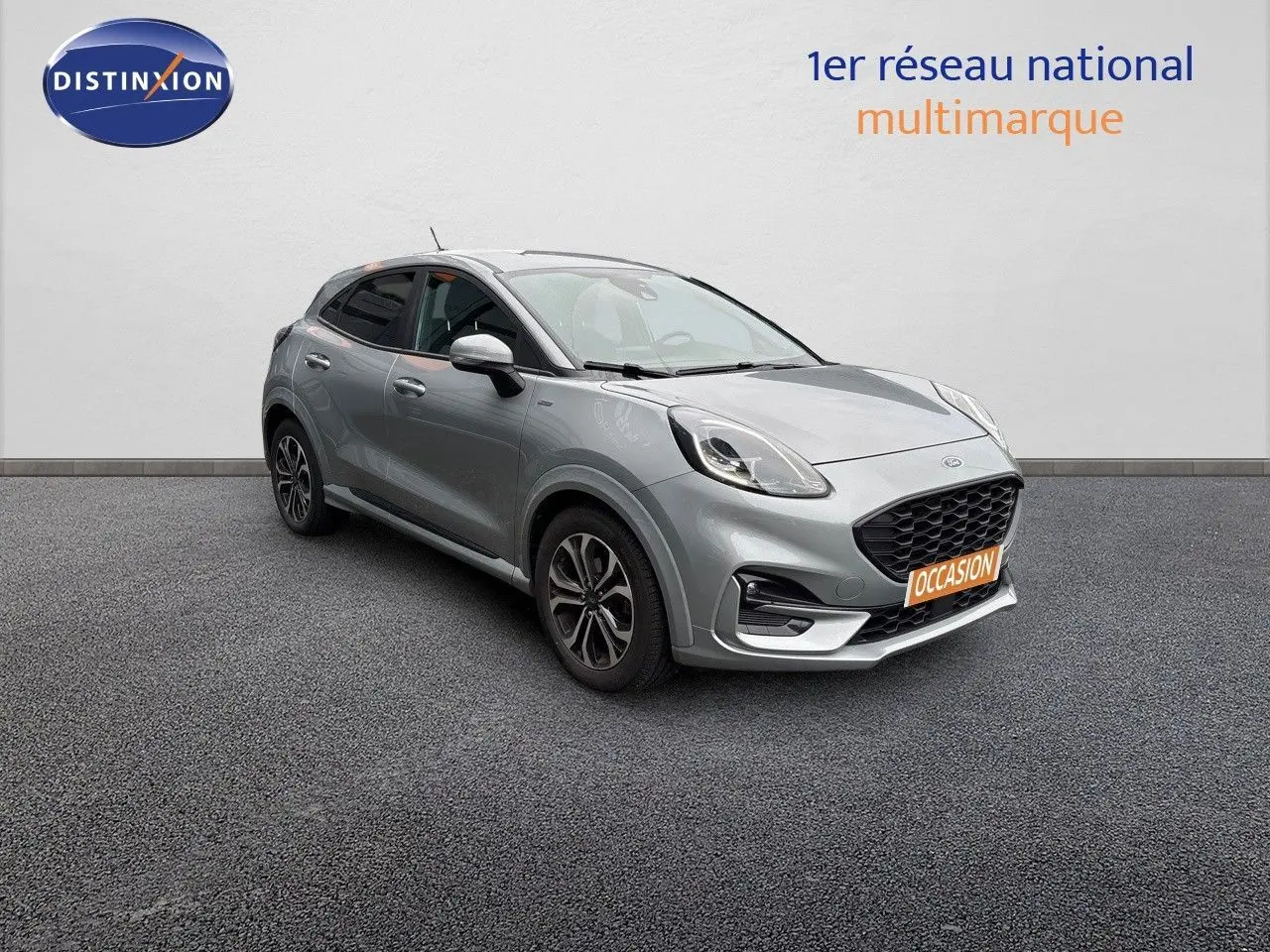 Ford Puma gris solar en 3/4 avant droit, avec calandre noire et jantes alliage distinctives.