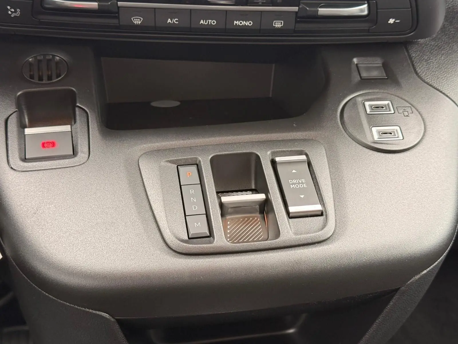 Vue rapprochée de la console centrale noire du Citroën Berlingo 2025, avec commandes de boîte auto et mode de conduite.