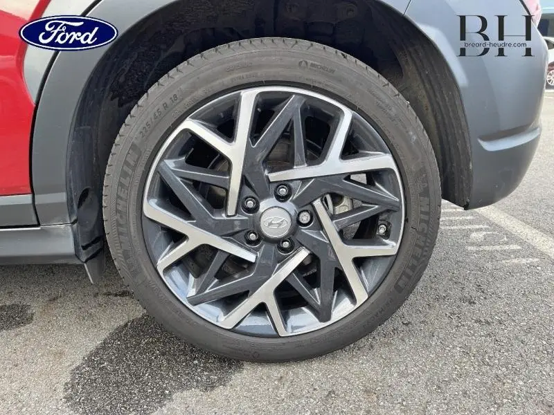 Gros plan sur la roue avant gauche du Hyundai Kona Pulse Red Métal avec jante alliage au design géométrique.