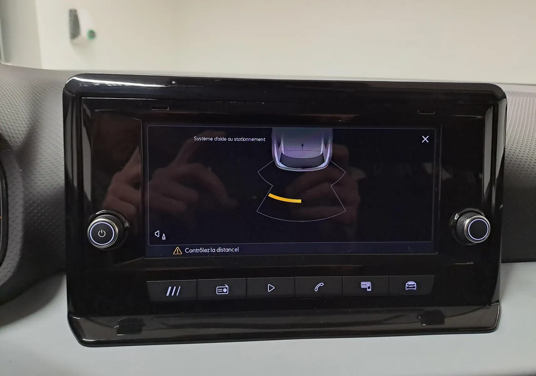 Écran tactile intérieur de la SEAT Ibiza 2024 montrant l'aide au stationnement avec interface noire brillante.