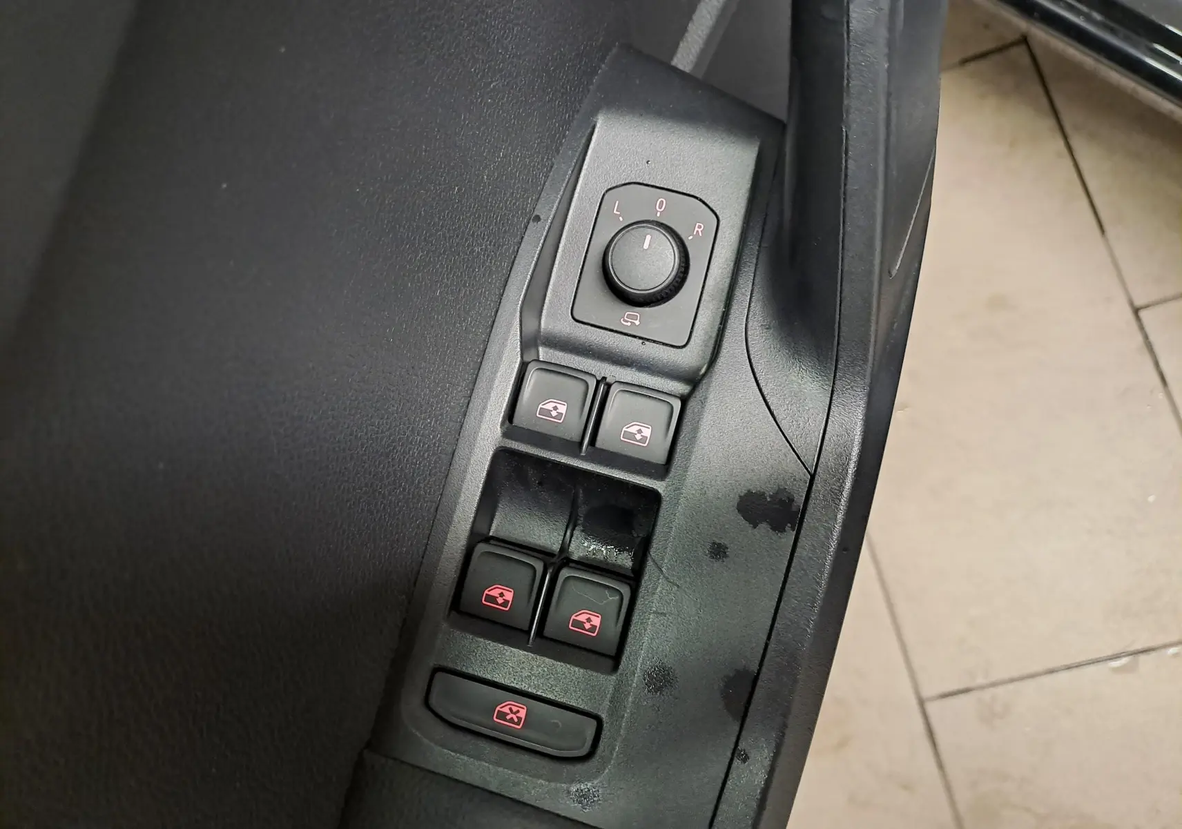 Gros plan sur les commandes des vitres et rétroviseurs côté conducteur d’une SEAT Ibiza noir minuit 2024.