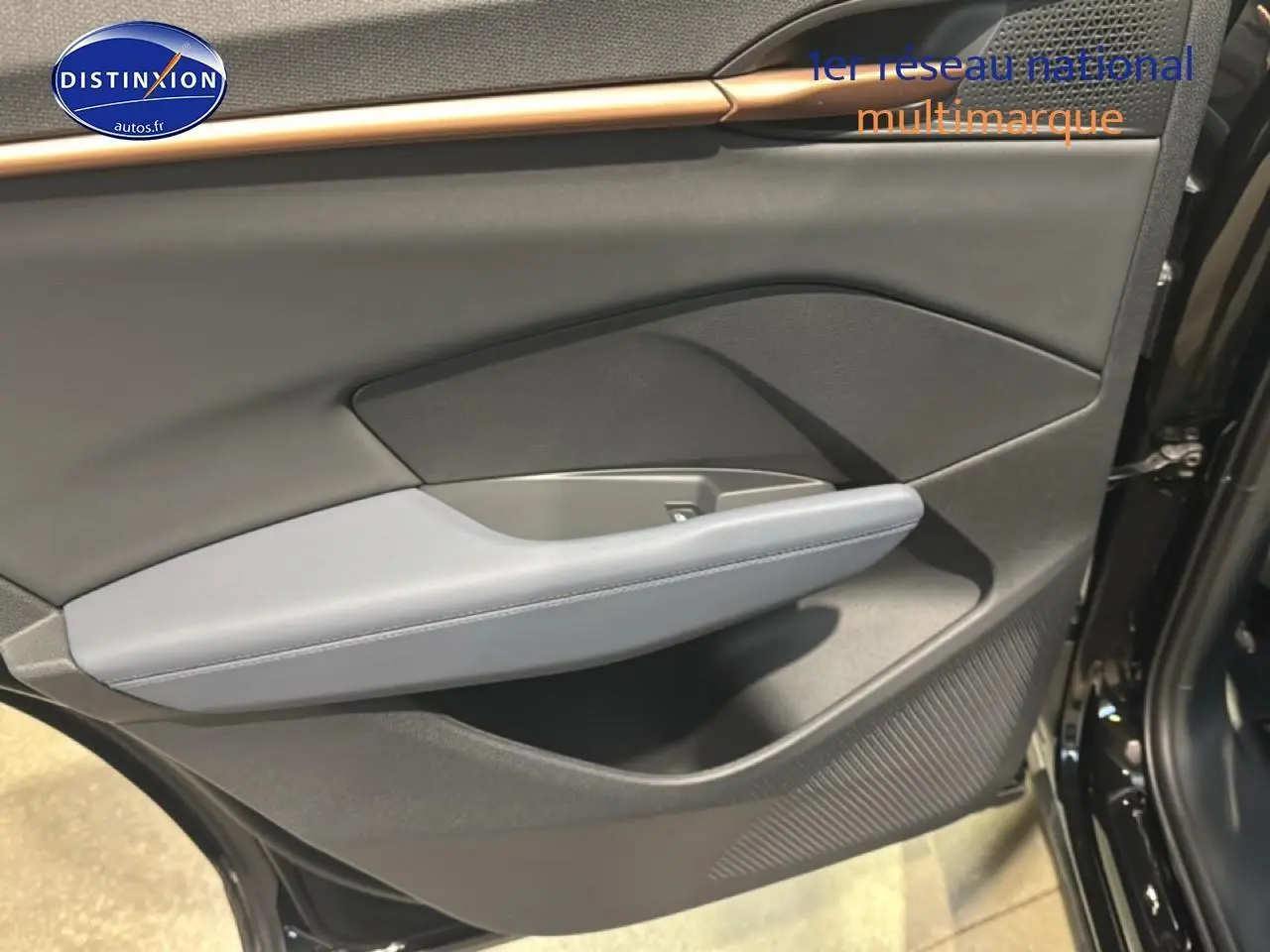 Vue intérieure côté droit de la porte arrière noire du CUPRA TERRAMAR 2025 avec accoudoir gris clair et finitions modernes.