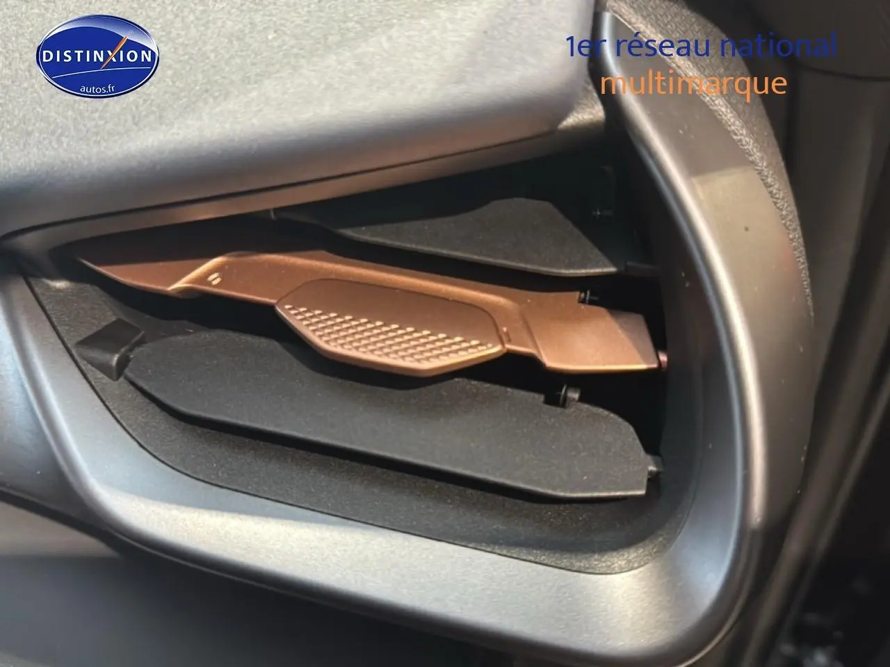 Détail de la boîte à gants ouverte avec insert marron dans l'habitacle d'une CUPRA TERRAMAR noire.