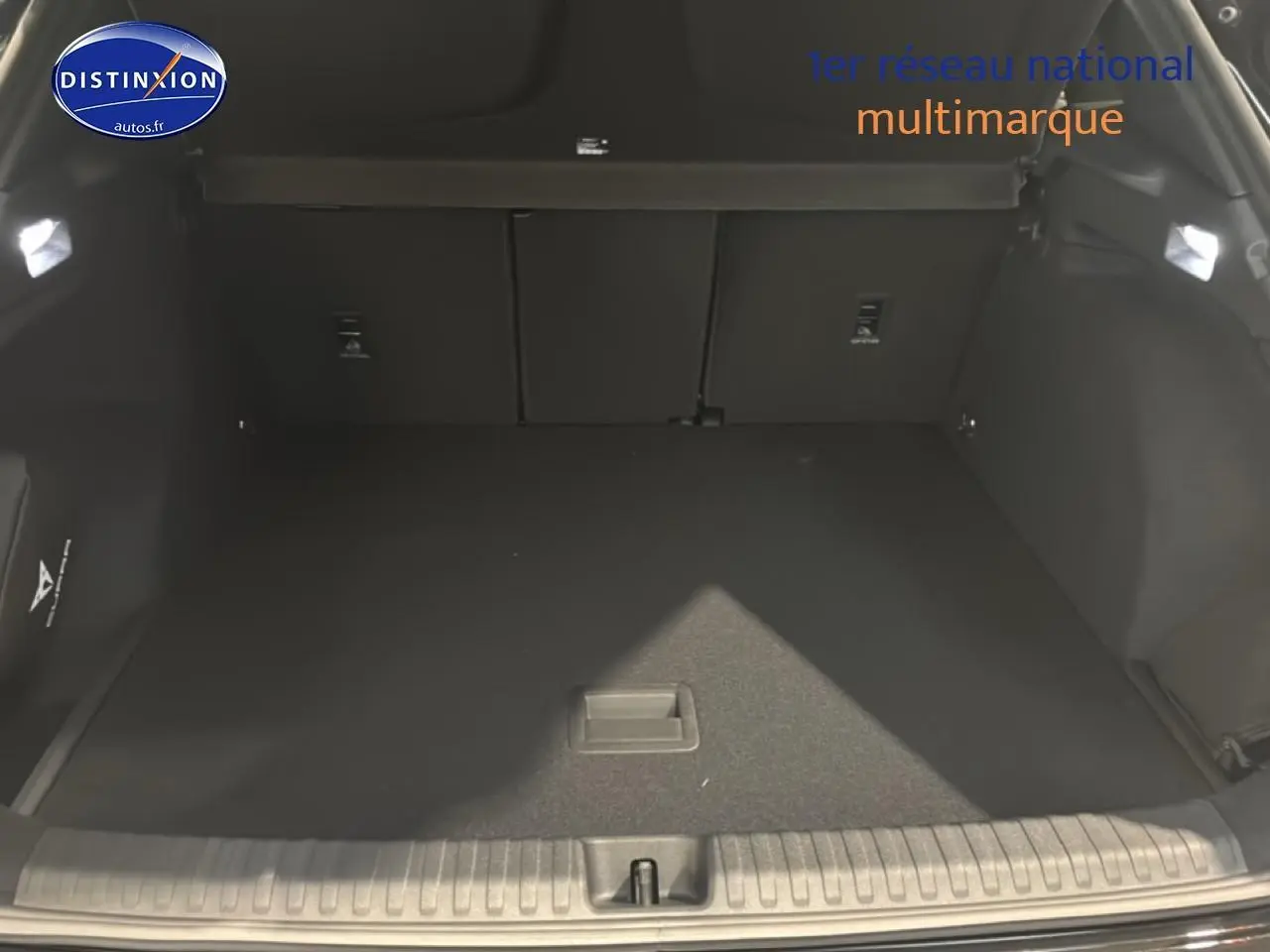 Coffre ouvert vu de l'arrière d'une CUPRA TERRAMAR noire, espace de chargement vide et tapis noir.