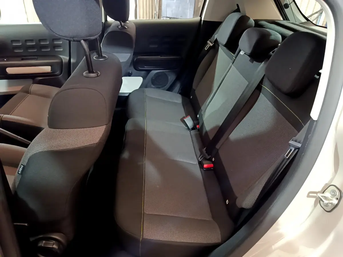 Vue intérieure côté droit des sièges arrière noirs de la Citroën C3 2022, avec ceinture de sécurité et appuie-têtes visibles.