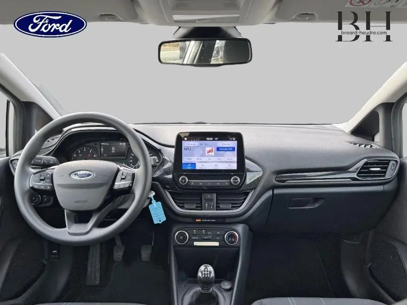 Vue intérieure avant du tableau de bord et volant de la Ford Fiesta 2020 gris lunaire avec écran tactile et boîte manuelle.