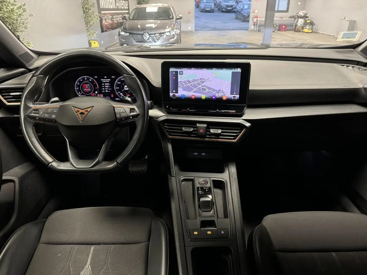 Vue intérieure frontale du tableau de bord du CUPRA Formentor gris, avec écran tactile central et volant sport multifonction.