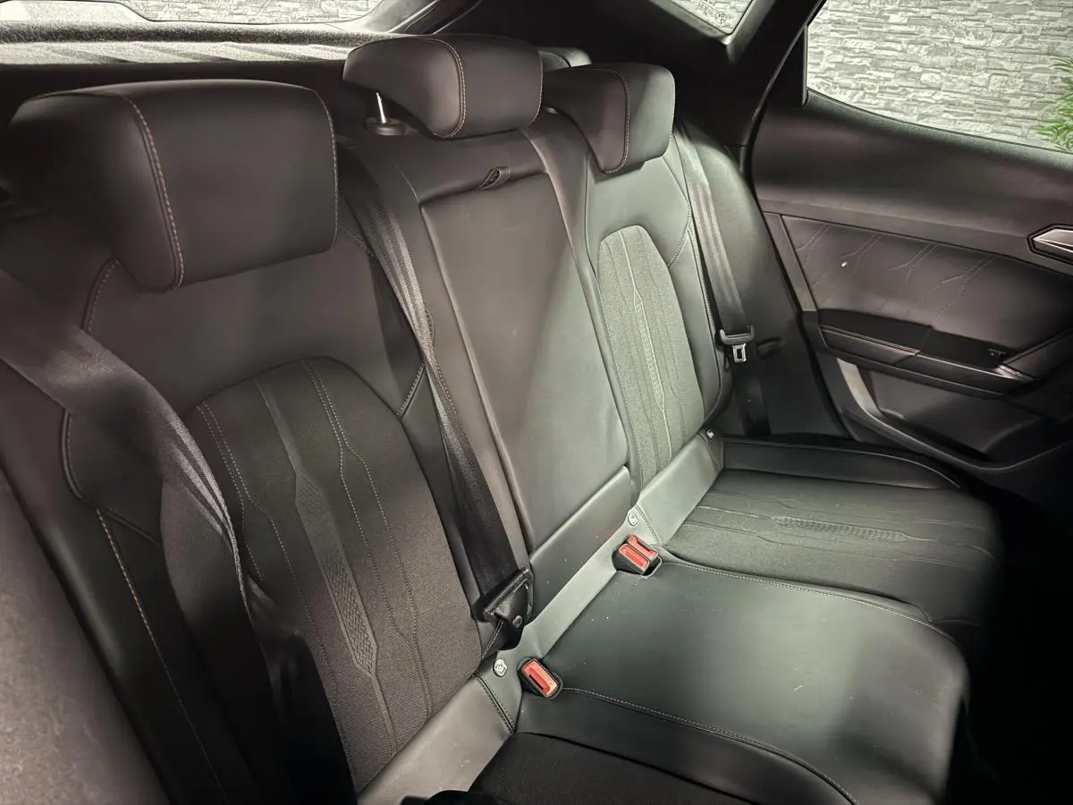 Vue intérieure des sièges arrière noirs en textile et similicuir du CUPRA Formentor 2023 avec surpiqûres contrastantes.