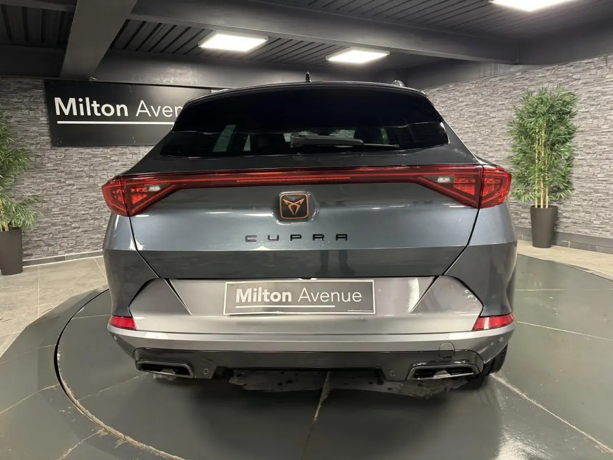 Vue arrière d'une CUPRA Formentor gris magnétique avec bandeau LED Infinite Light et double sortie d'échappement noire.