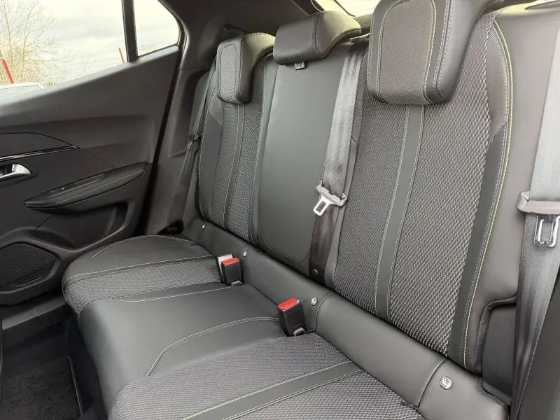 Vue latérale gauche de la banquette arrière noire avec surpiqûres vertes du Peugeot 2008 Hybrid 2025.