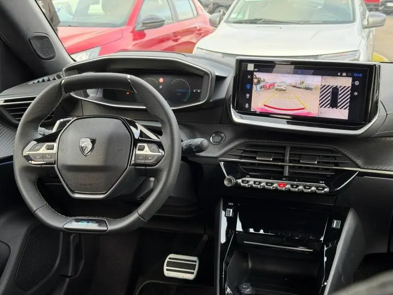 Vue intérieure du tableau de bord et volant cuir multifonction du Peugeot 2008 Hybrid bleu, avec écran tactile affichant la caméra de recul.