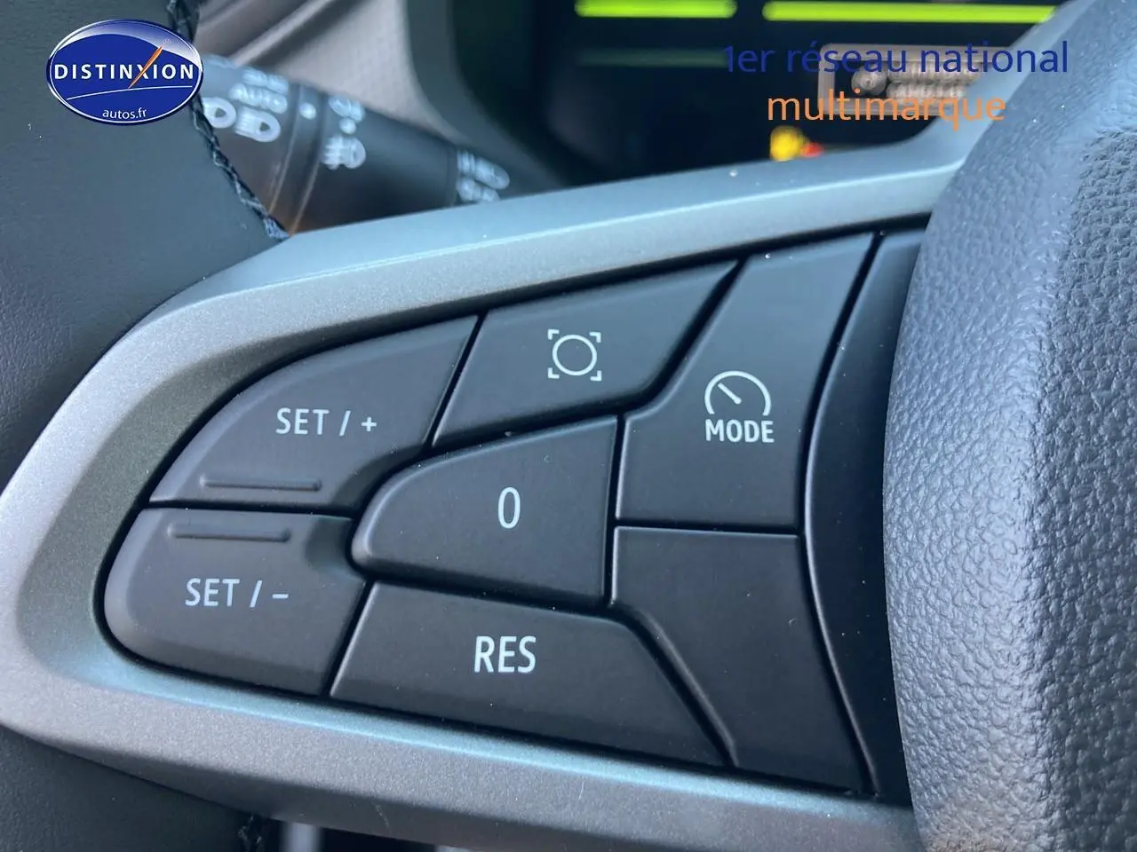 Gros plan sur les commandes multifonctions à gauche du volant du Dacia Duster gris schiste 2026.