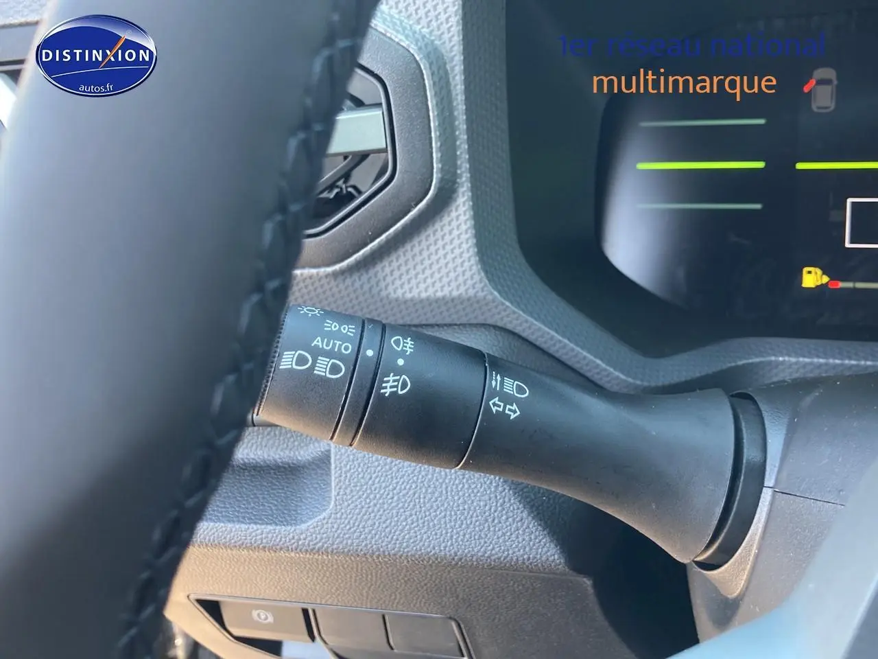 Gros plan sur la manette de commande des phares à gauche du volant du Dacia Duster gris schiste, intérieur moderne.