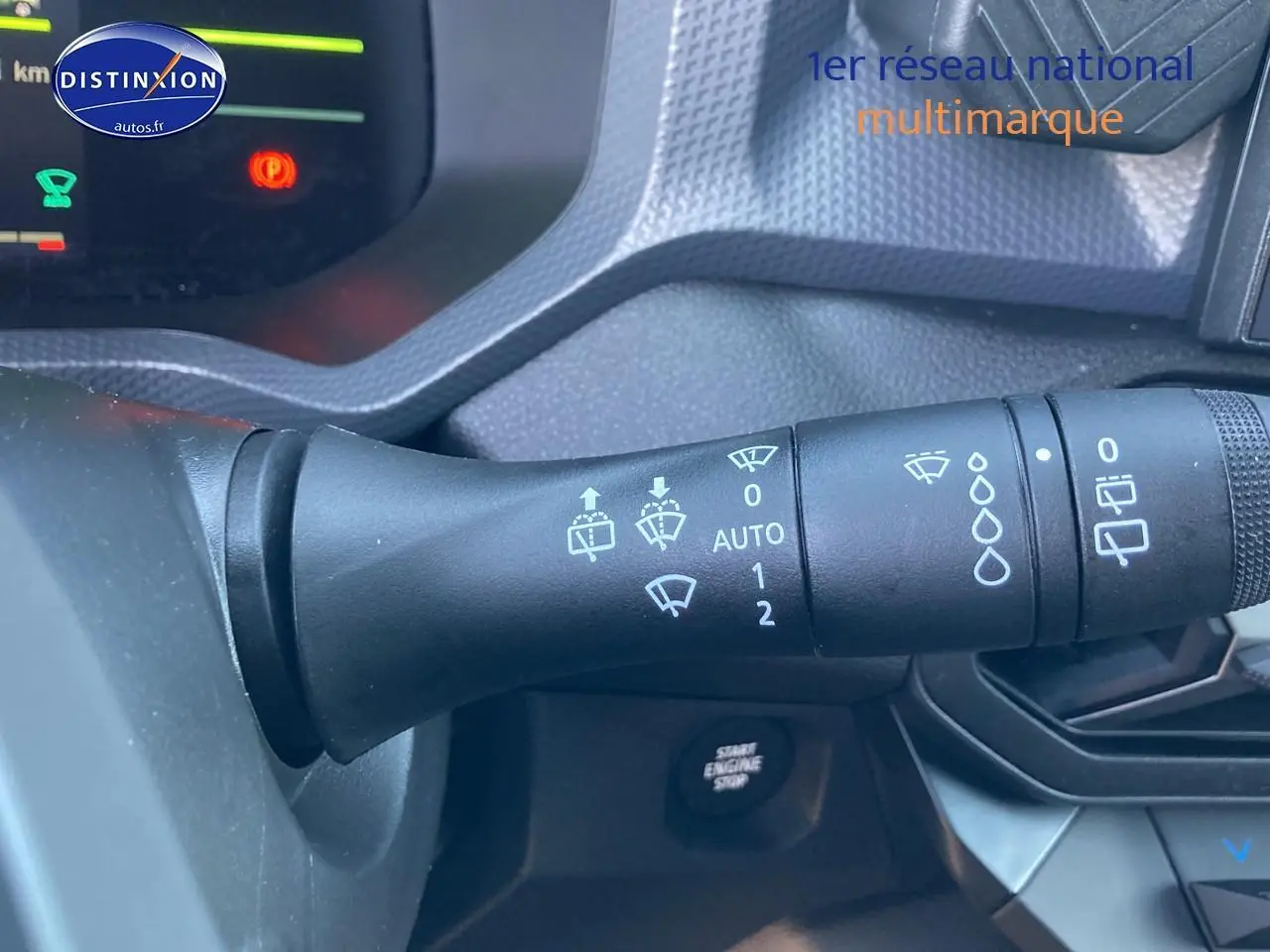 Gros plan sur la commande d’essuie-glace du DACIA Duster gris schiste, avec tableau de bord et bouton start visible.