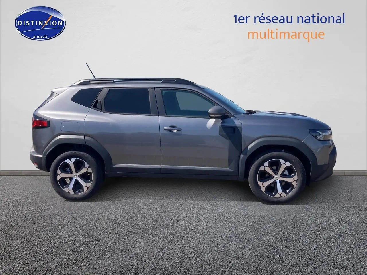 Vue latérale droite du Dacia Duster 2026 gris schiste avec jantes alliage et vitres arrière surteintées.