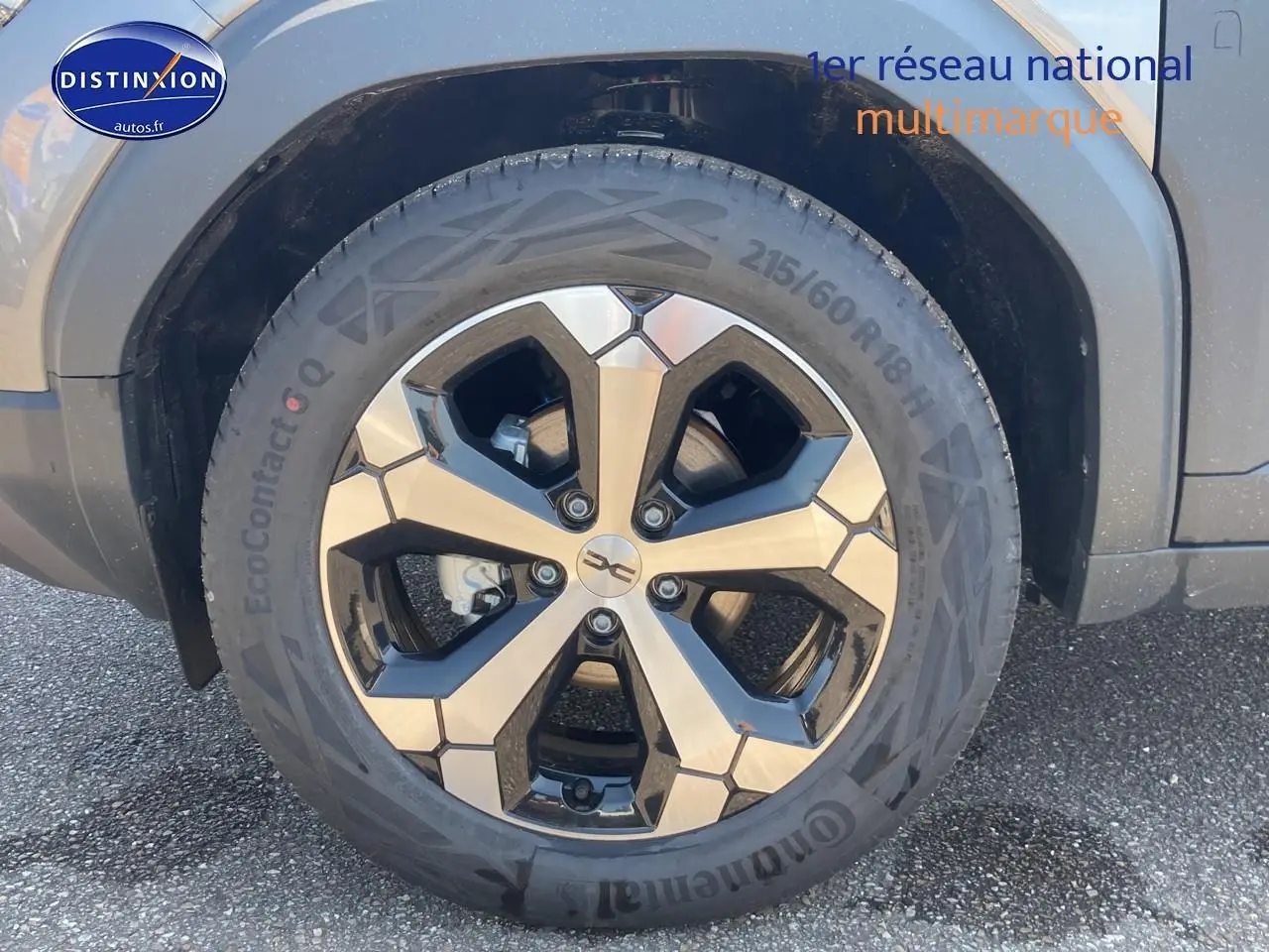 Gros plan sur la roue avant droite du Dacia Duster gris schiste, mettant en valeur la jante alu moderne.