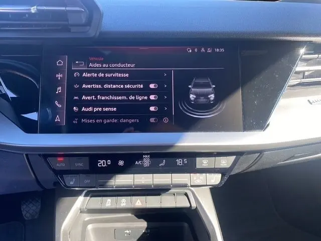 Vue rapprochée de l'écran tactile et de la console centrale du tableau de bord gris foncé de l'Audi A3 30 TDI 116 Business Line 2021.