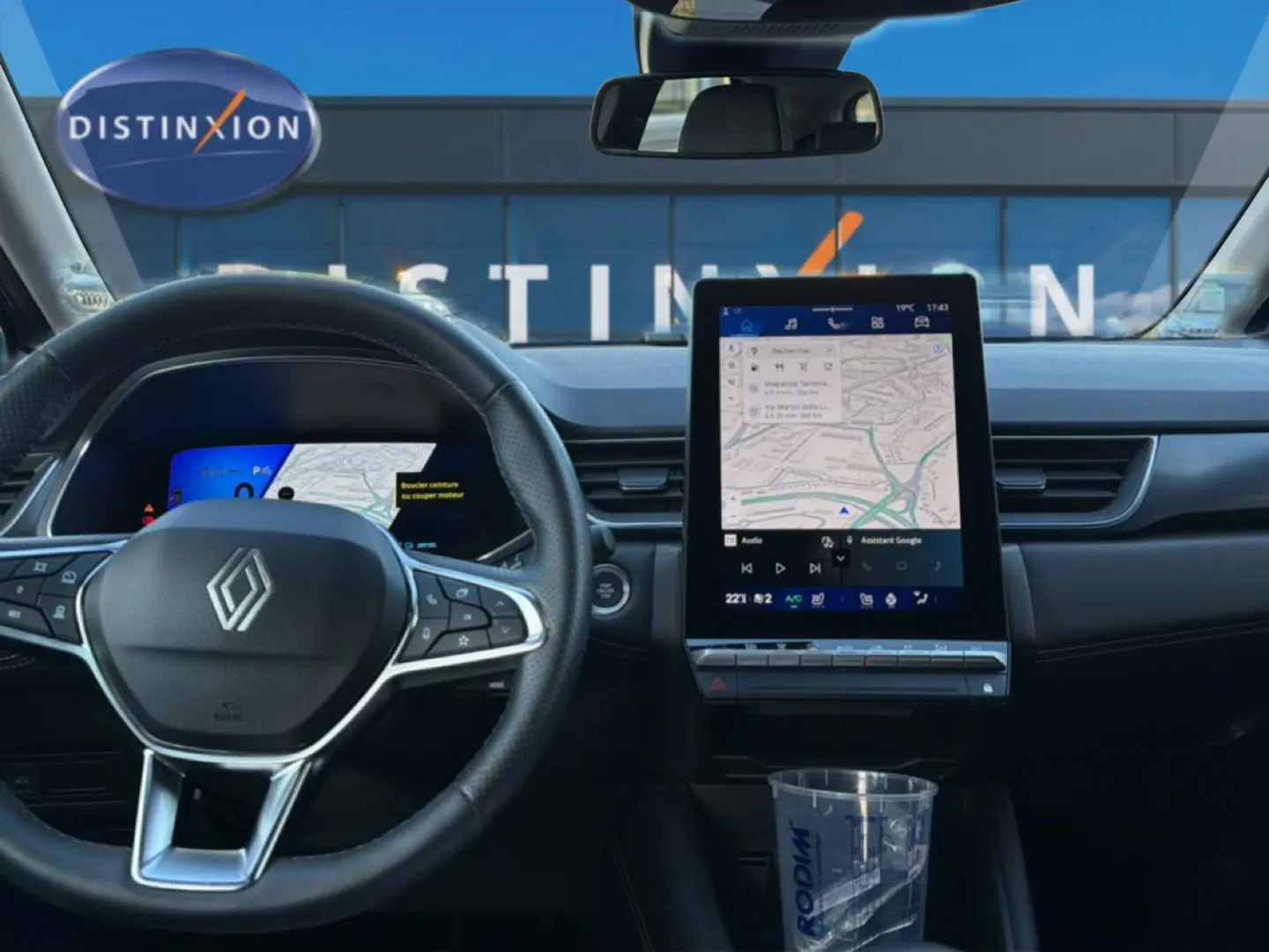Vue intérieure avant du tableau de bord noir du Renault Symbioz 2025 avec écran tactile vertical et volant multifonction.