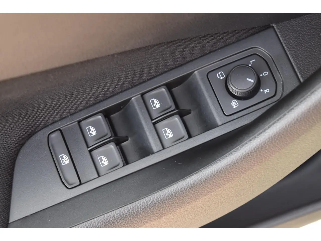 Gros plan sur les commandes de lève-vitres et réglage des rétroviseurs côté conducteur d'une Skoda Scala 2025.