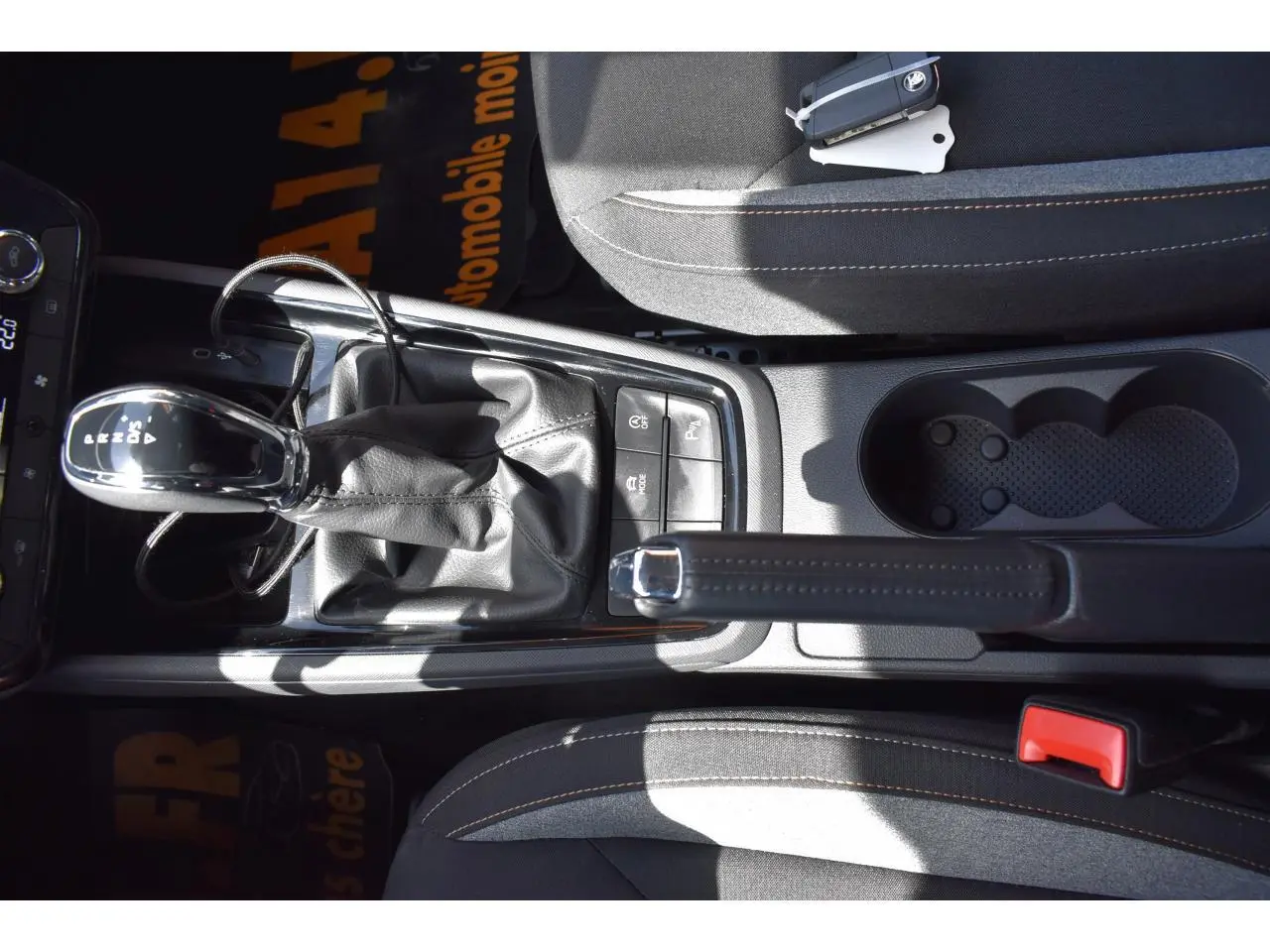 Vue plongeante sur la console centrale de la Skoda Scala graphite, avec levier de boîte auto et frein à main manuel.