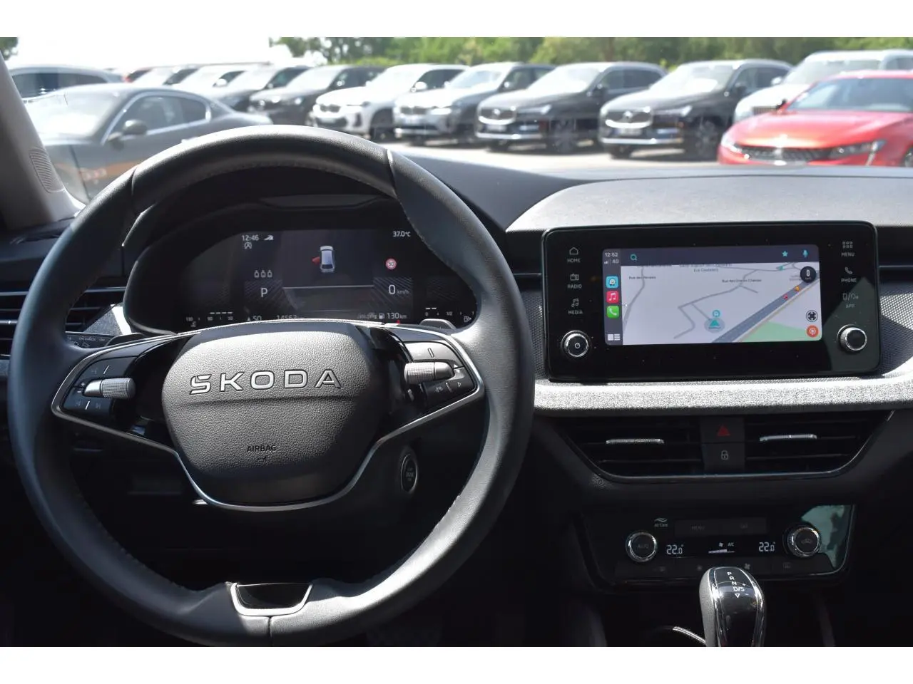 Vue intérieure centrée sur le volant noir Skoda et l'écran tactile 8,25'' affichant la navigation.