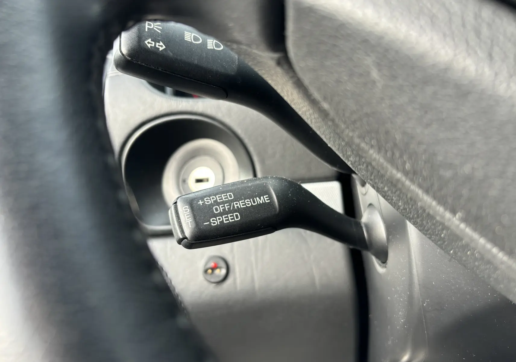 Gros plan sur les commandes de régulateur de vitesse et clignotants dans l'habitacle noir d'une Porsche Cayenne S 2007.