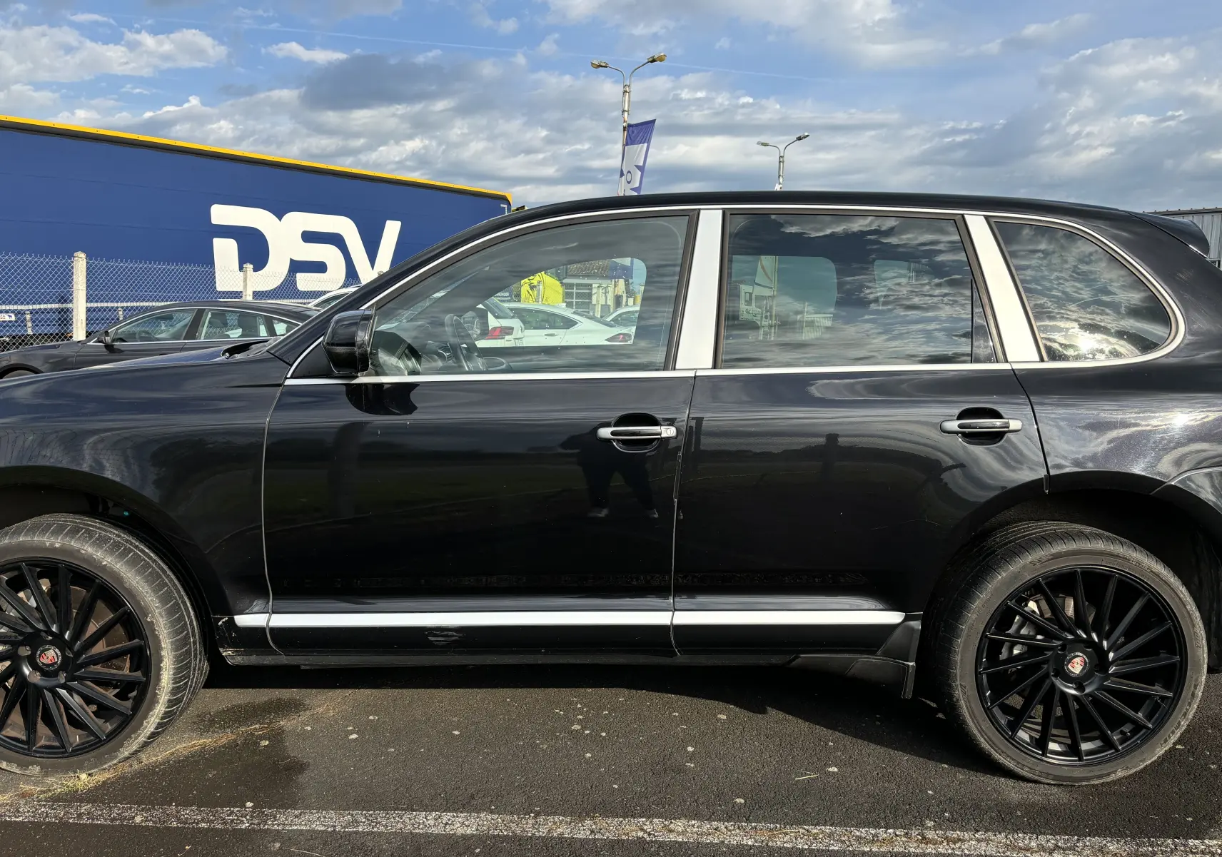 Vue de profil côté gauche d'un Porsche Cayenne S noir de 2007 avec jantes noires multibranches distinctives.