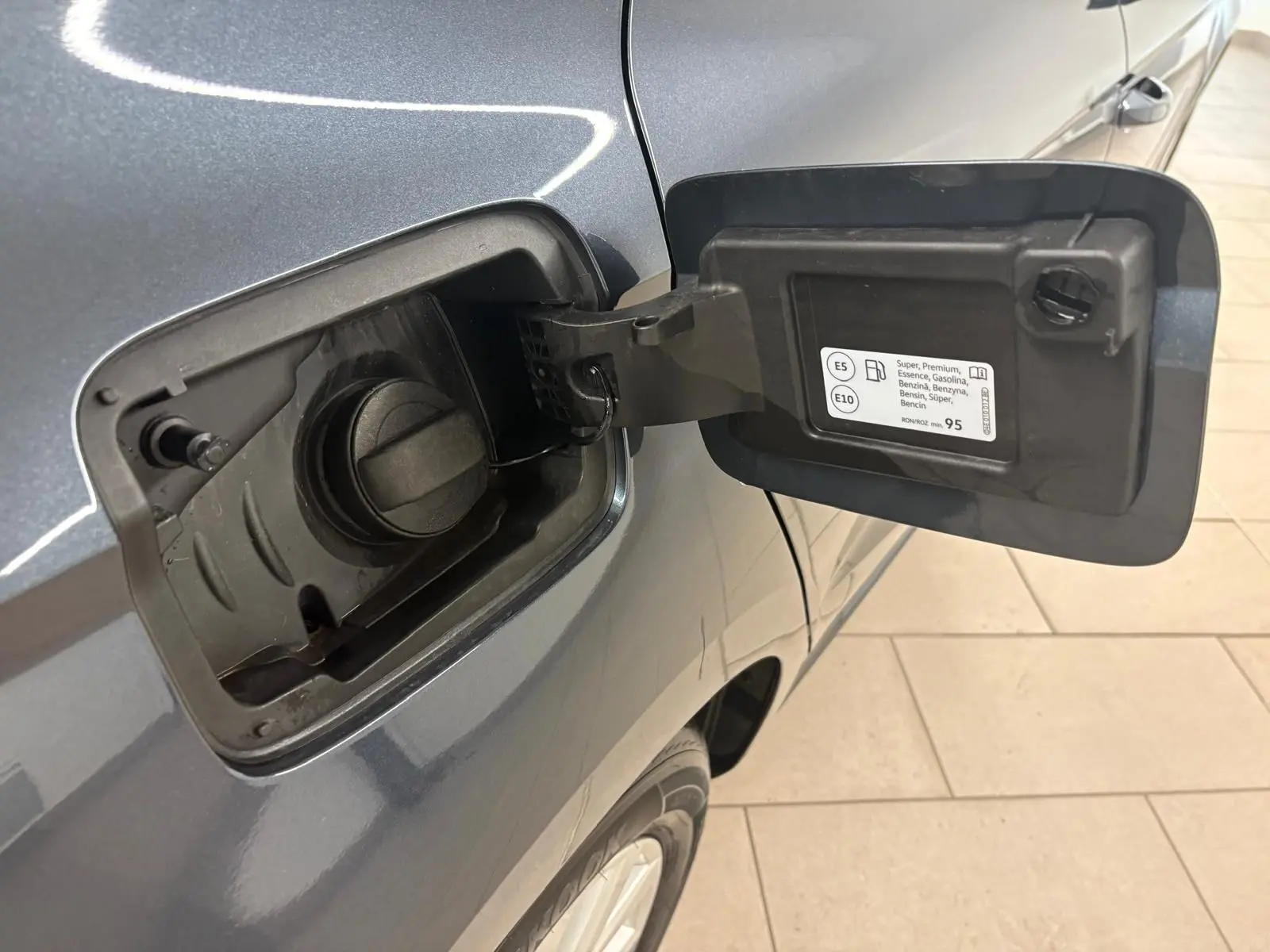 Trappe à carburant ouverte côté gauche d’une SEAT Ibiza gris magnétique 2024, avec bouchon essence visible.