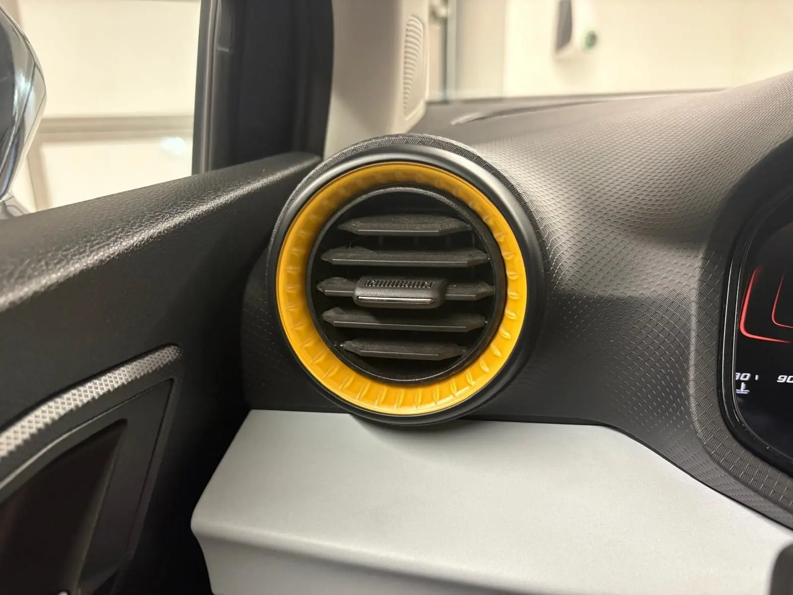 Détail de la sortie d’air ronde avec cerclage jaune sur le tableau de bord côté gauche de la SEAT Ibiza 2024 gris magnétique.