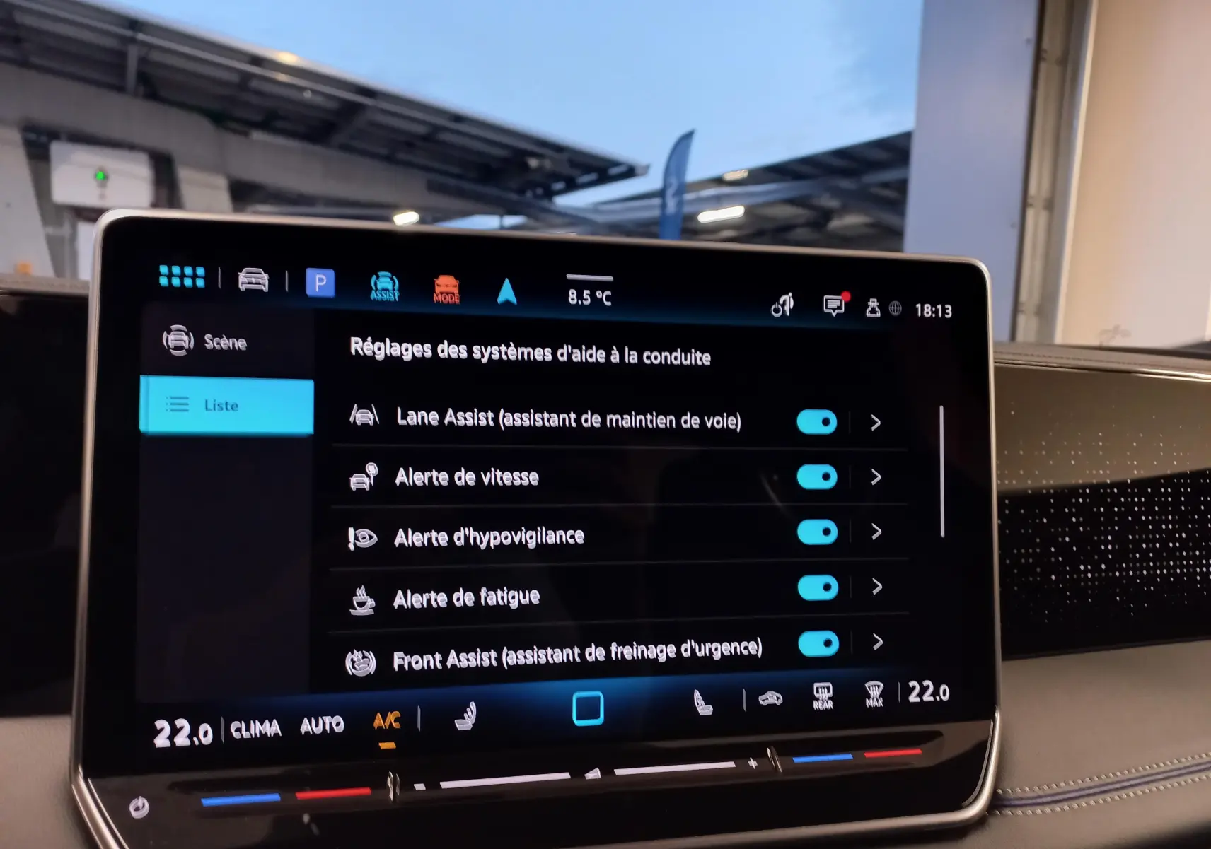 Écran tactile intérieur du Volkswagen Tiguan 2025 montrant les réglages des aides à la conduite en ambiance de tableau de bord.