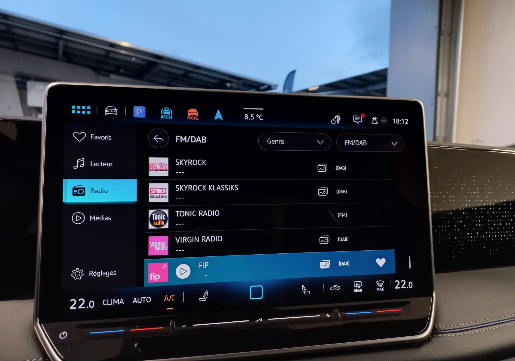 Écran tactile central du Volkswagen Tiguan 2025 affichant la sélection radio FM/DAB avec interface moderne et commandes climatisation.