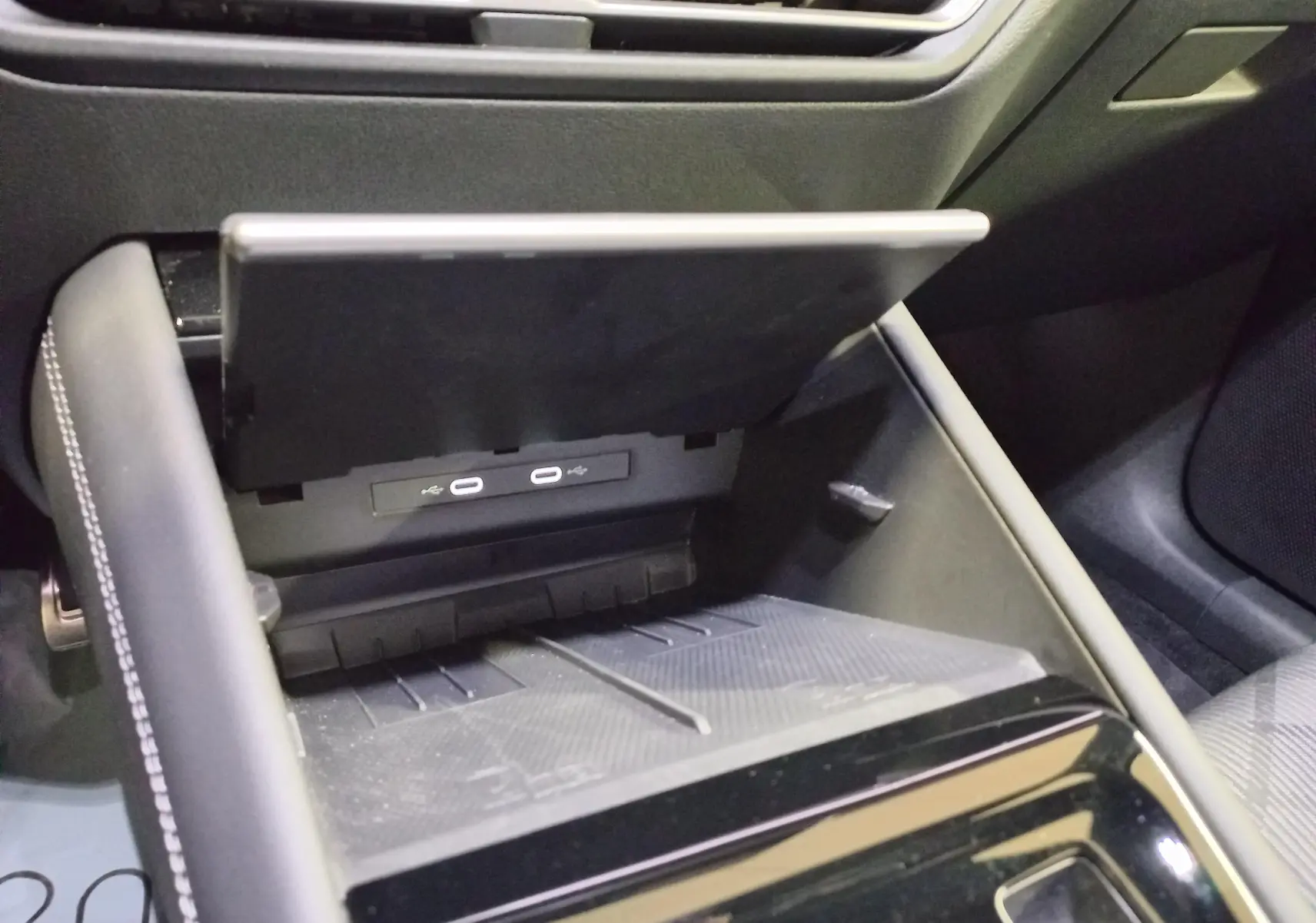 Gros plan intérieur sur la console centrale du Volkswagen Tiguan 2025, montrant le compartiment ouvert avec ports USB-C.