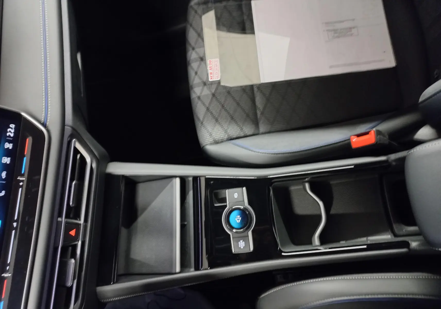 Vue intérieure centrée sur la console centrale et siège avant droit avec surpiqûres bleues du Volkswagen Tiguan 2025.