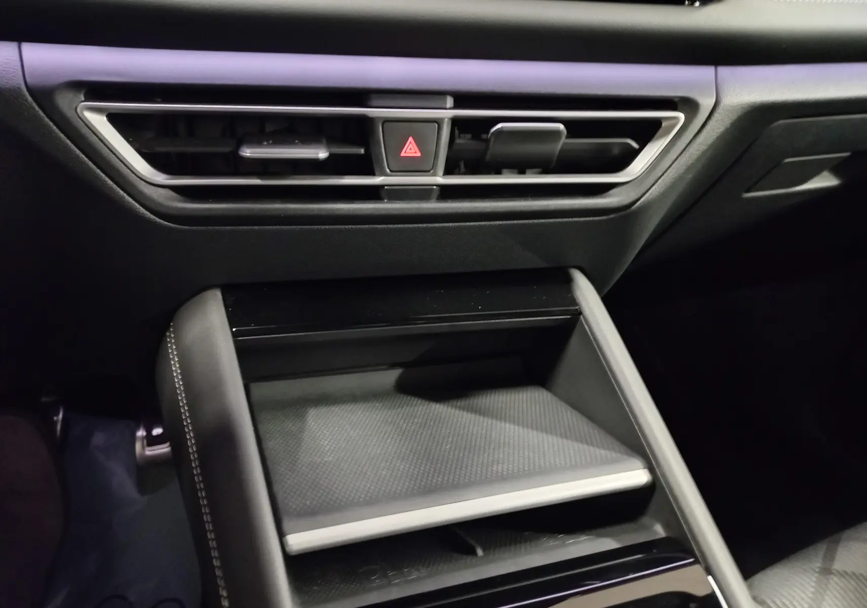 Détail de la console centrale noire avec aérateurs et bouton de warning du Volkswagen Tiguan 2025 intérieur.