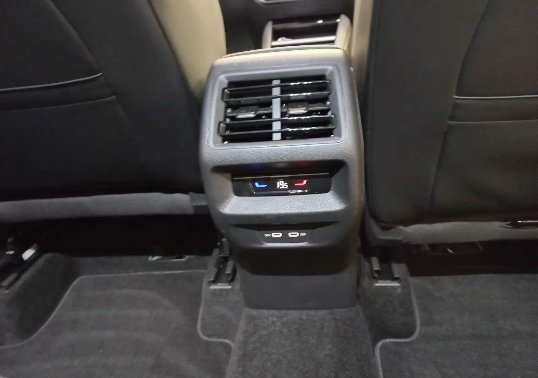 Vue rapprochée de la console arrière noire avec commandes de climatisation et ports USB du Volkswagen Tiguan 2025.