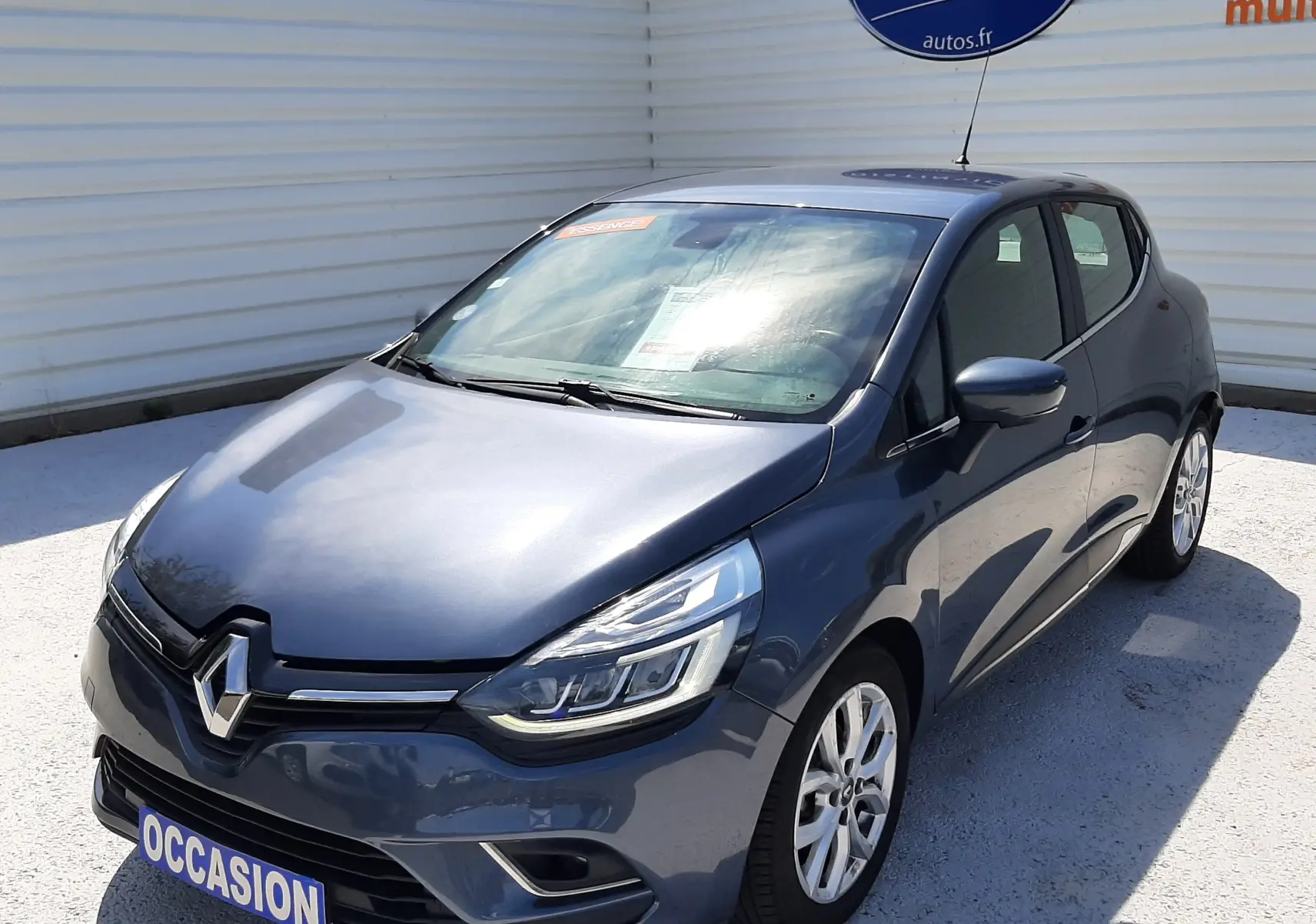 Renault Clio IV gris titanium vue 3/4 avant droit, compacte cinq portes avec phares LED et jantes alliage.
