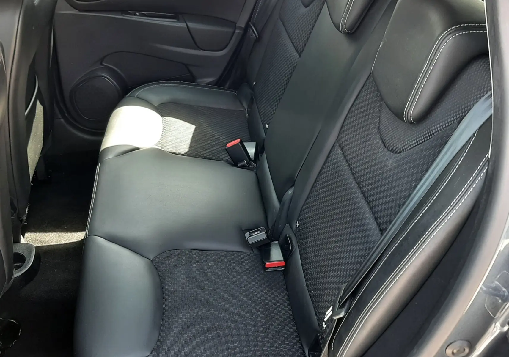 Vue intérieure côté droit des sièges arrière en cuir et tissu noir de la Renault Clio IV gris titanium 2016.