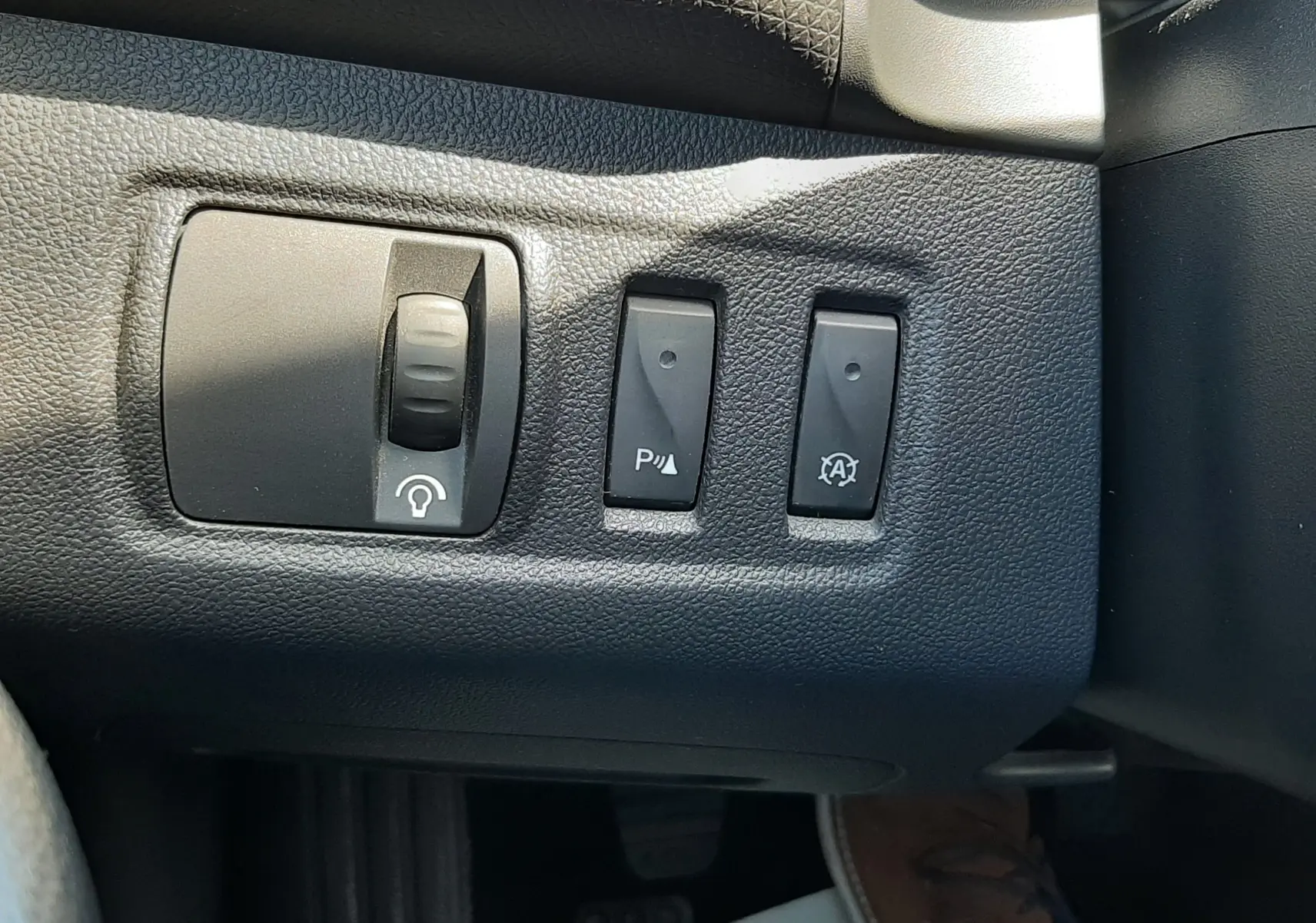 Gros plan sur les commandes noires du tableau de bord côté gauche d’une Renault Clio IV gris titanium de 2016.