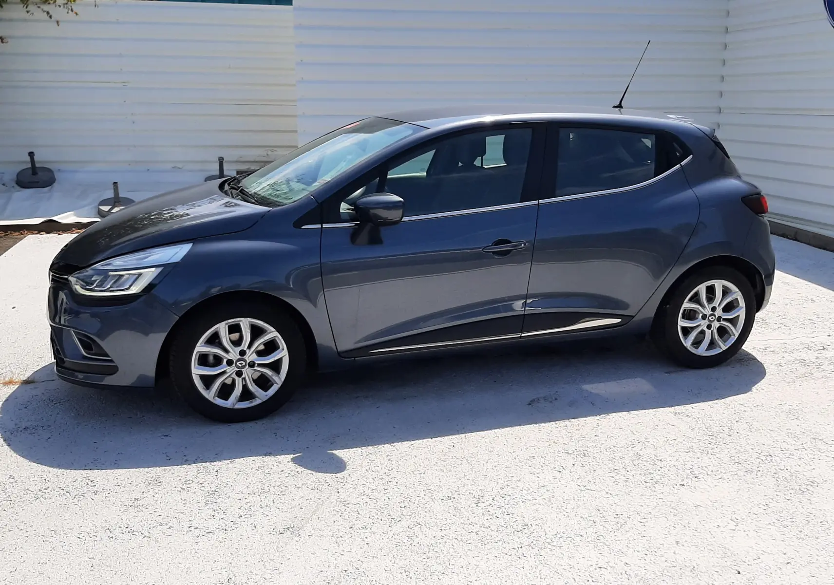 Renault Clio IV gris titanium vue de profil côté gauche, avec jantes alliage et lignes épurées.